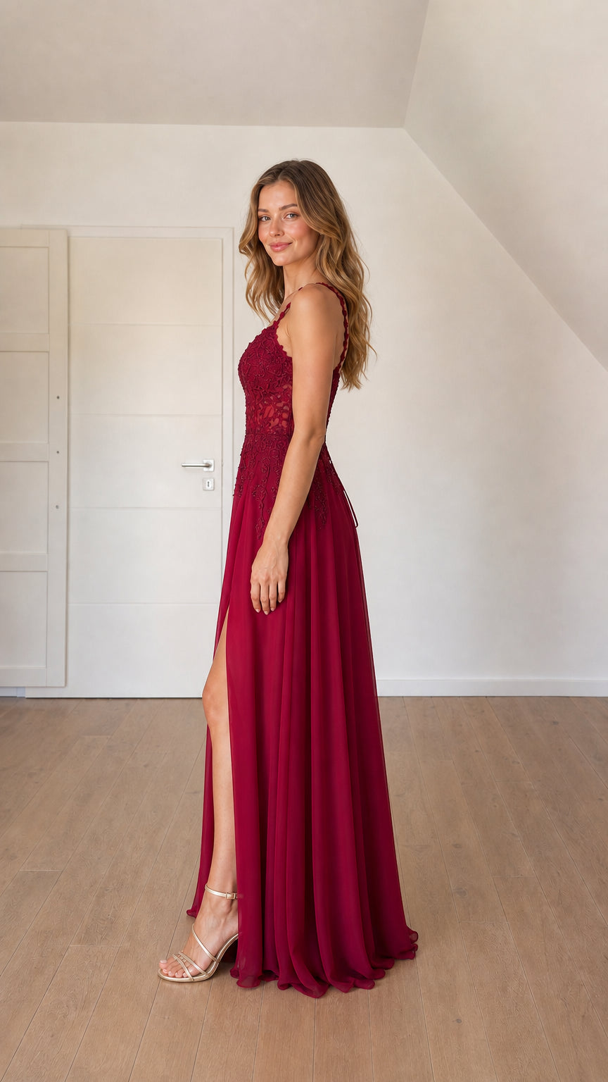 Side profile of woman in burgundy floor-length evening dress showing high leg slit
