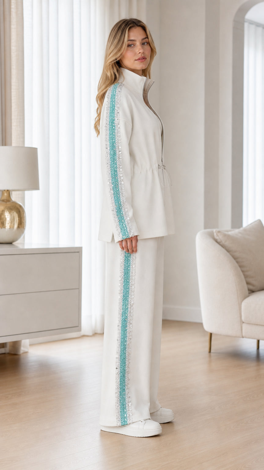 Side view of woman wearing white two-piece tracksuit and wide-leg pants