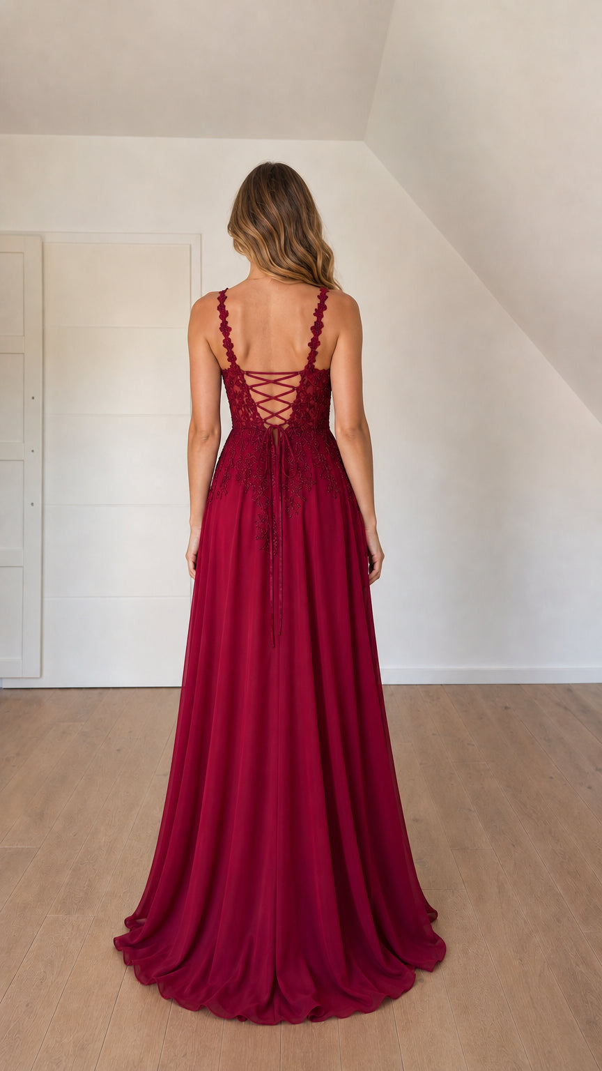 Back view of woman showing crisscross lace-up corset detail on burgundy maxi gown