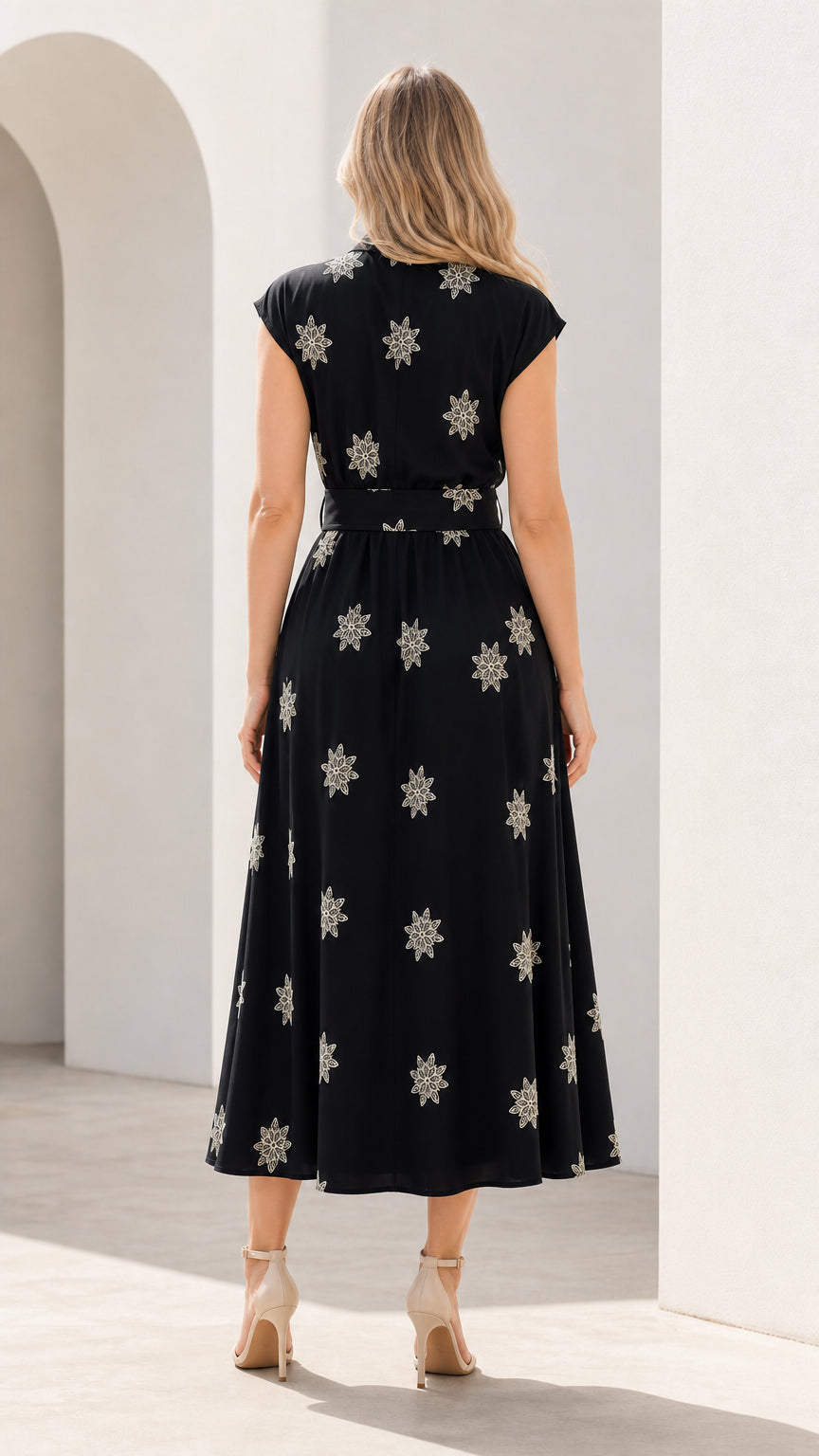 Back view of woman wearing black embroidered midi dress