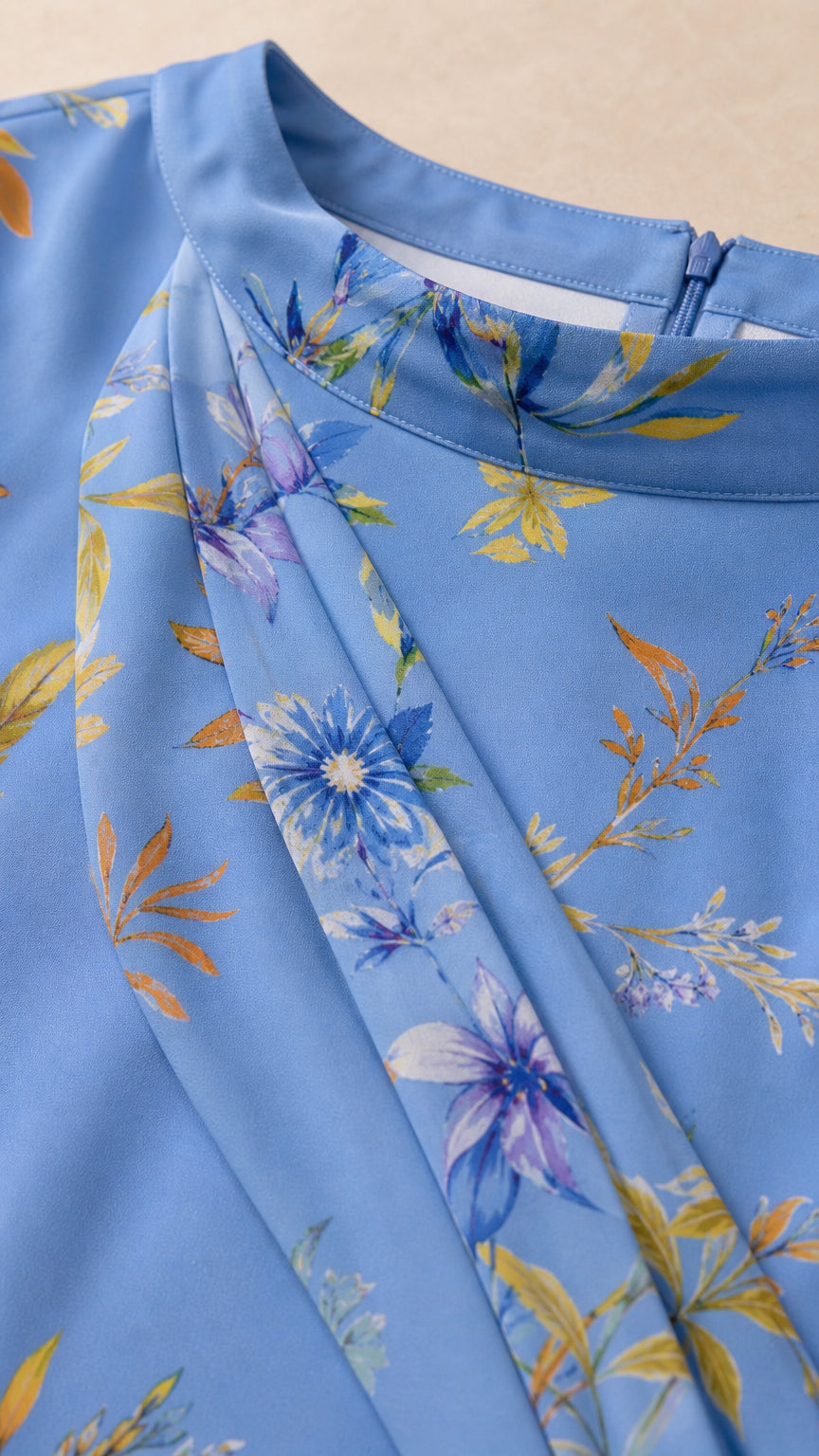 Close-up detail of high neckline with gathered pleating and floral fabric texture