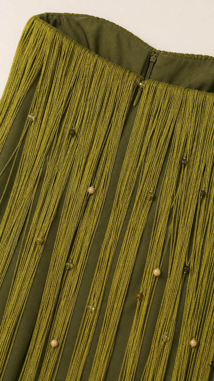 Close-up detail of beaded fringe texture and concealed zip on olive green dress