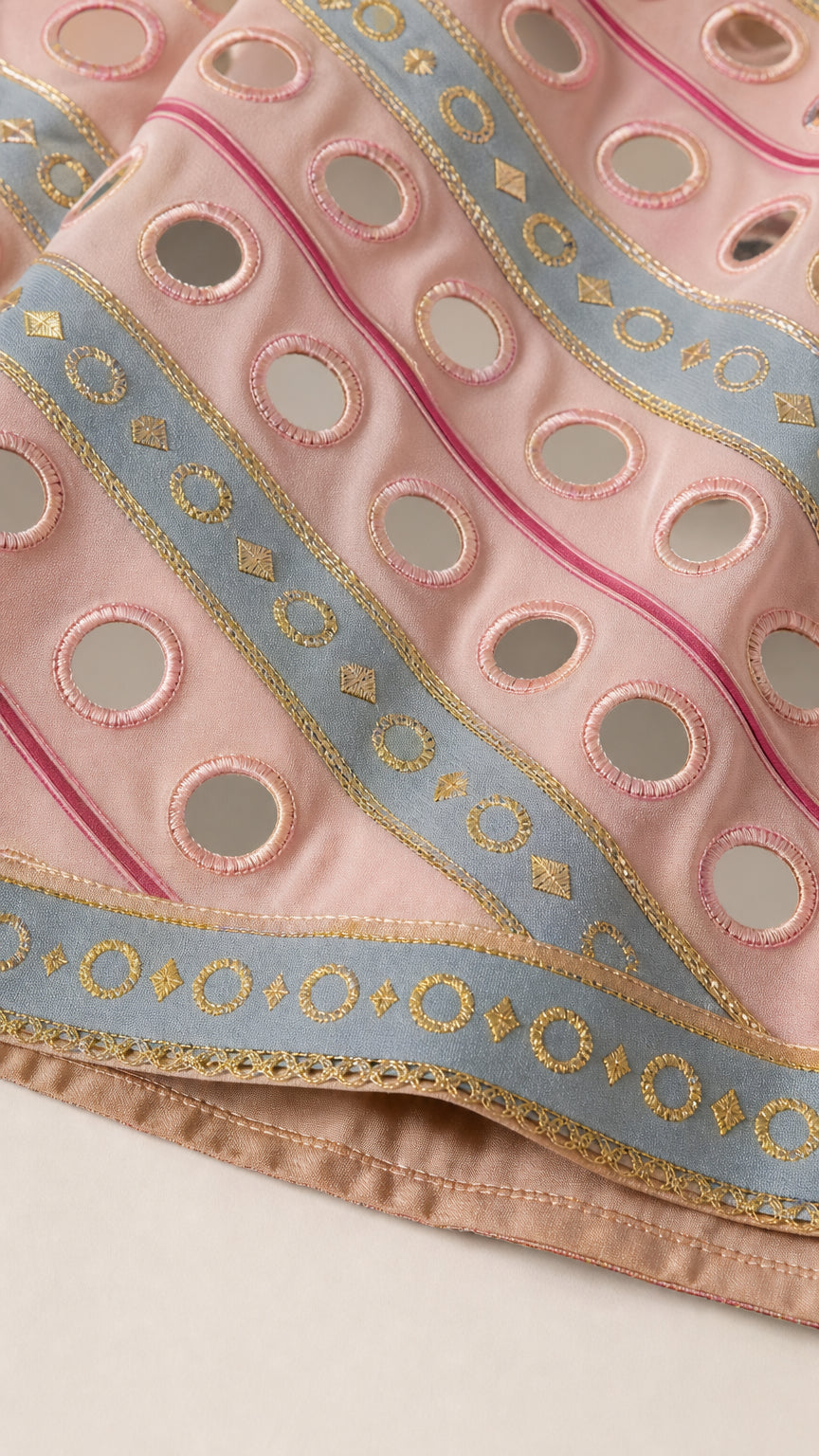 Close-up detail of mirror cutouts and metallic embroidery on hem