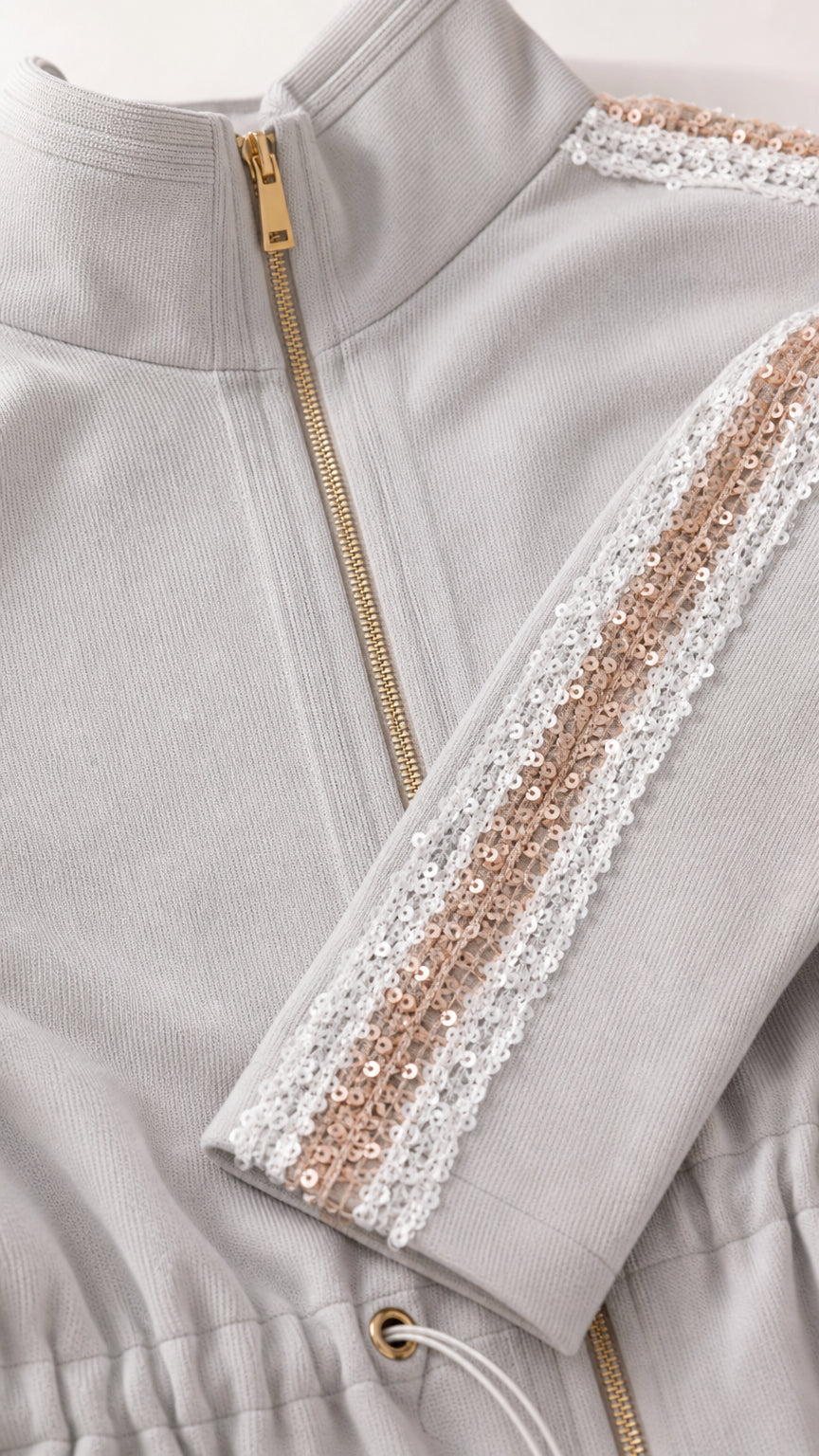 Close-up detail of zipper, ribbed texture, and sequin ribbon side trim