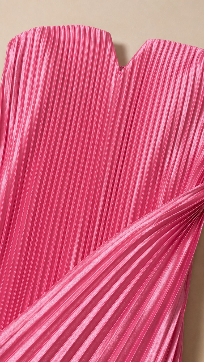 Close-up detail of fuchsia pink accordion pleated fabric and V-notch neckline