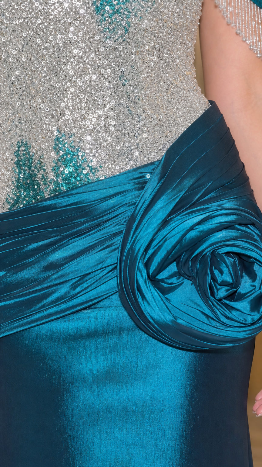 Close-up detail of beaded bodice, fringed off-shoulder strap, and draped satin rosette