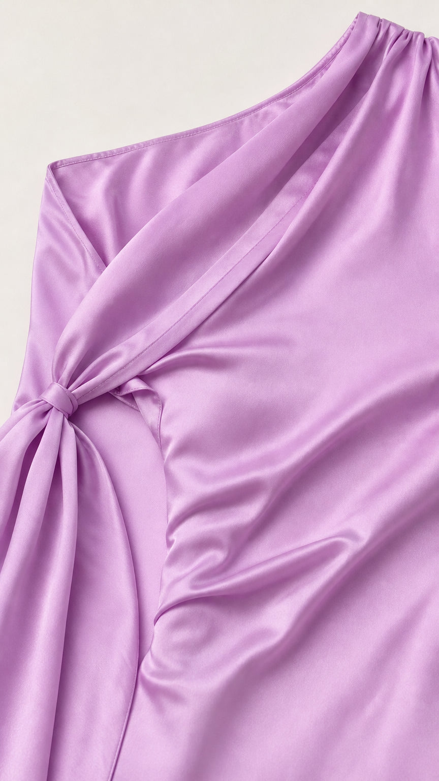 Close-up of knotted shoulder drape detail on lavender satin dress