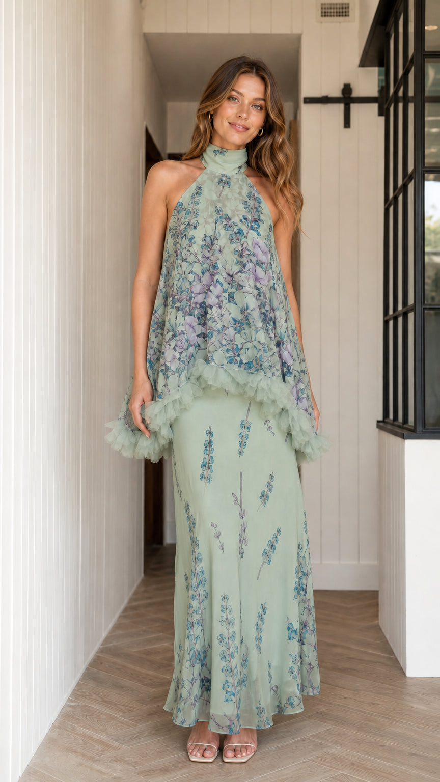 Model wearing sage green floral halter maxi dress with ruffle overlay