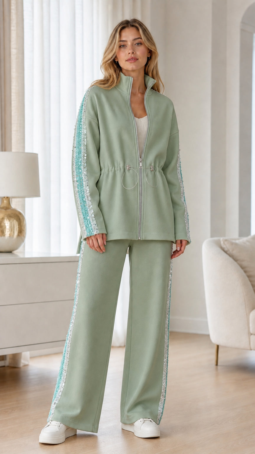 Full-length view of woman wearing sage green zip-up jacket and wide-leg pants set